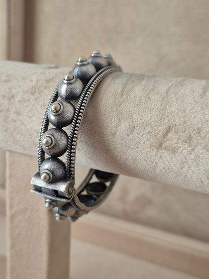Close-up of Naitri Aksha silver bangle bracelet featuring traditional Indian style engraving and a clasp closure by naitri.in