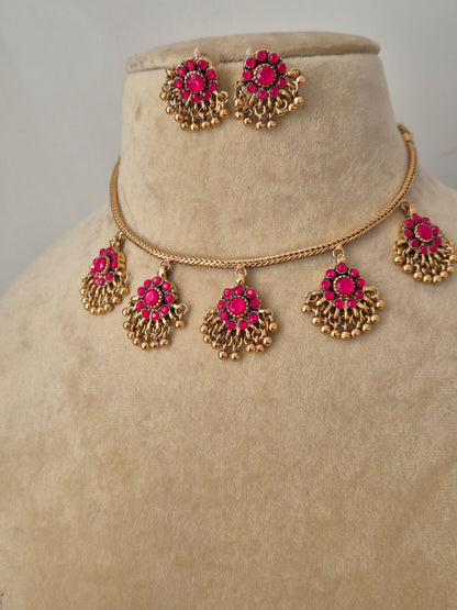 Gold-tone brass alloy necklace featuring five dangling pink stone charms in a fan-shaped design with tiny gold bead drops, paired with matching pink studs by naitri.in