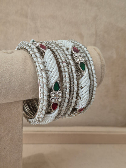 Close-up of Naitri premium silver plated ethnic Kada bangles showcasing traditional temple jewelry craftsmanship with a brilliant red stone embellishment by naitri.in