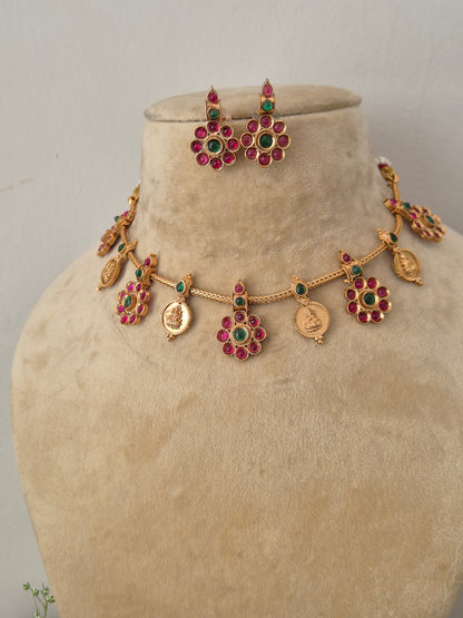 Elegant multi-colored stone and gold-toned traditional choker jewelry set, Gold-plated choker necklace with red and green gemstones, traditional coin drops, and matching earrings by naitri.in