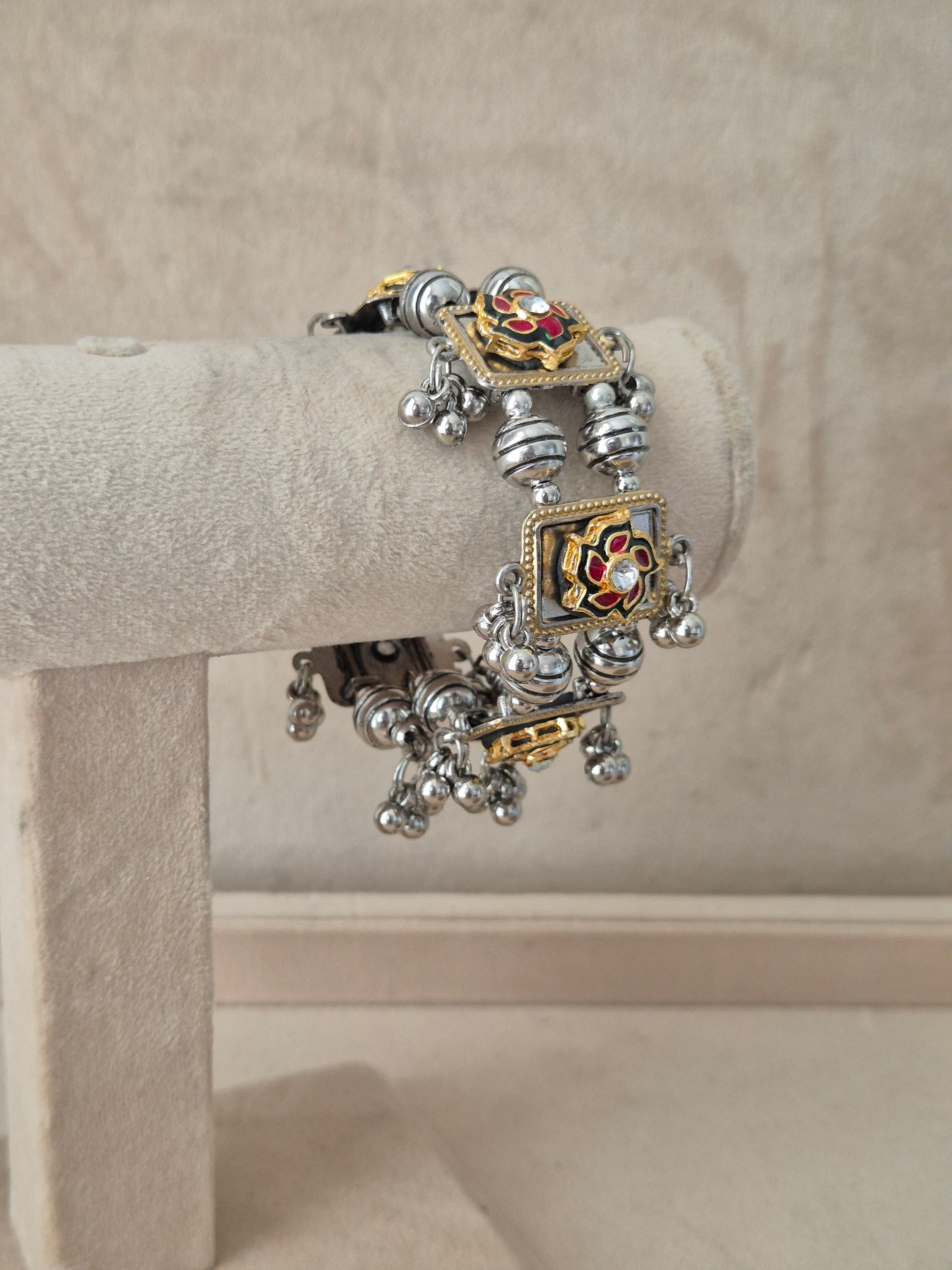 Close-up of Naitri Apeksha premium oxidized silver and gold-accented ethnic bracelet showcasing traditional tribal jewelry craftsmanship with dangling bell charms by naitri.in