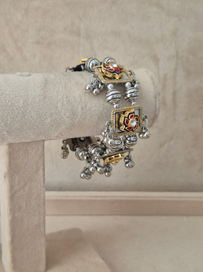 Close-up of Naitri Apeksha premium oxidized silver and gold-accented ethnic bracelet showcasing traditional tribal jewelry craftsmanship with dangling bell charms by naitri.in