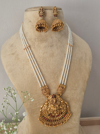 Modern Indian ethnic imitation jewelry set including a multi-layered white pearl strand necklace with a large textured golden temple pendant, by naitri.in