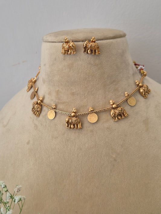 Modern Indian ethnic imitation jewelry set including a multi-charm golden brass alloy choker necklace and matching small jhumka earrings, by naitri.in