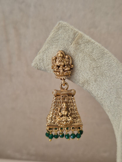 Close-up of Naitri Bhumika premium gold ethnic earrings showcasing traditional Indian temple architecture craftsmanship and vibrant green stone embellishments by naitri.in
