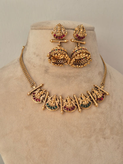 Gold-toned traditional jewelry set, including a necklace with deity motifs and matching earrings by naitri.in