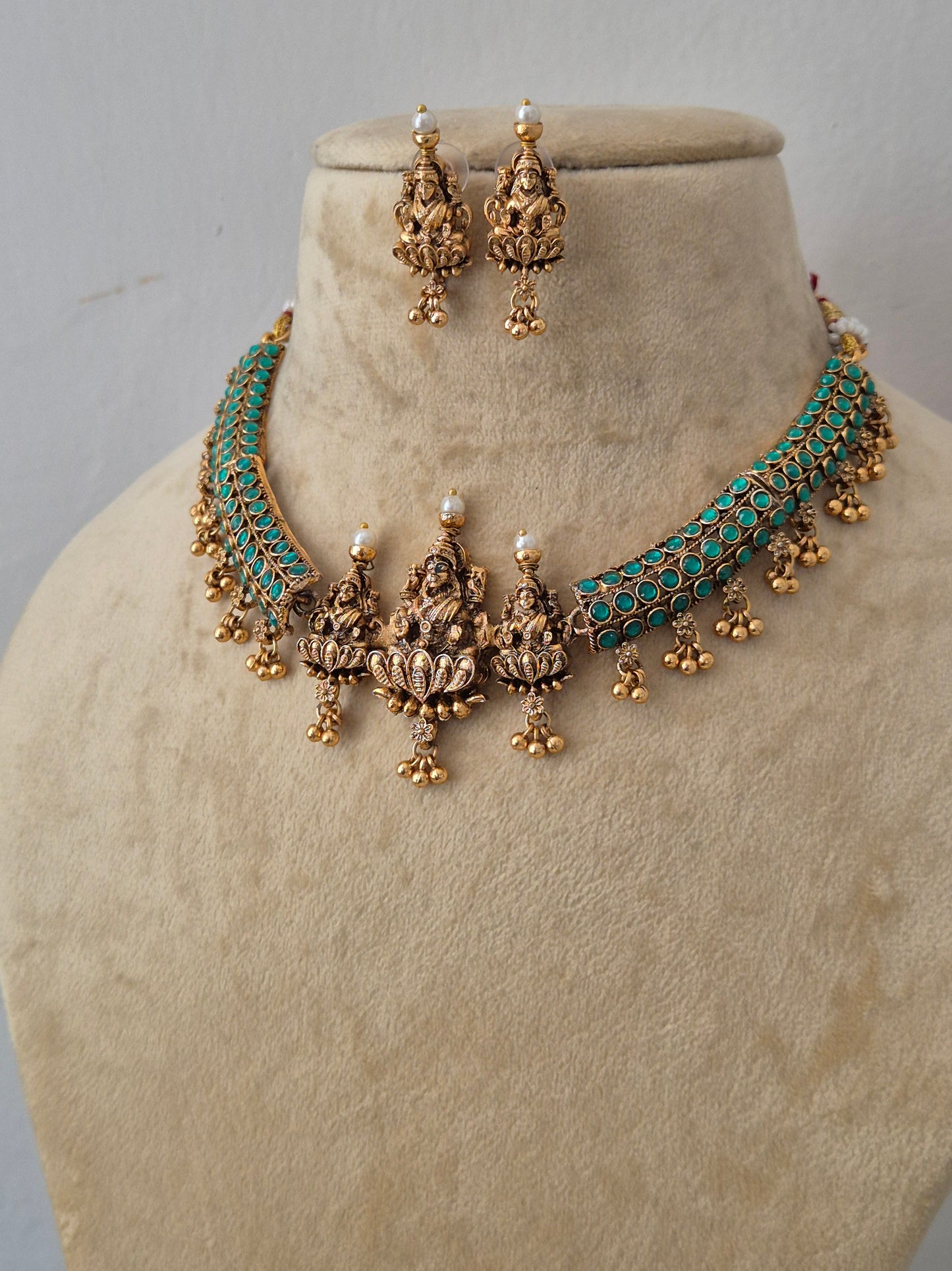 Gold-plated choker necklace and matching drop earrings with turquoise blue stone inlay and small white pearl accentsby naitri.in