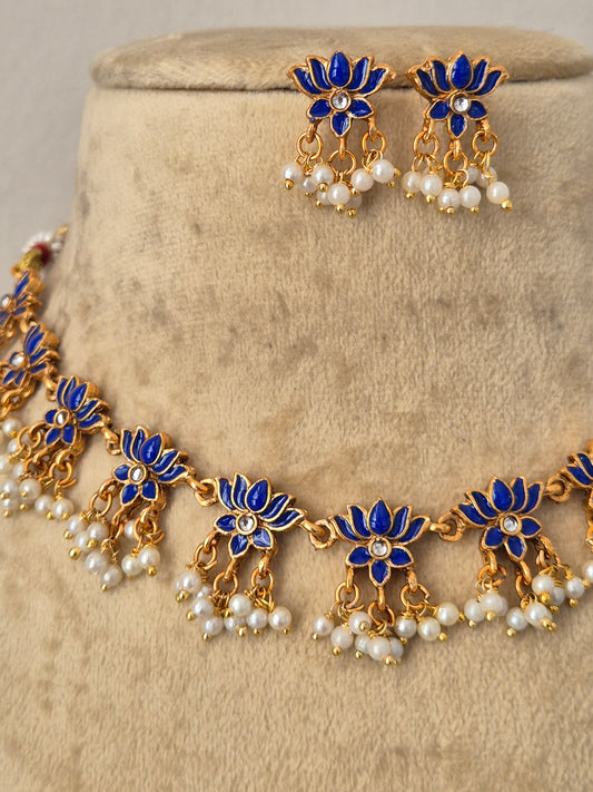 Gold-plated Indian ethnic choker set featuring a textured floral pattern with blue gemstone details and delicate dangling white pearls, by naitri.in