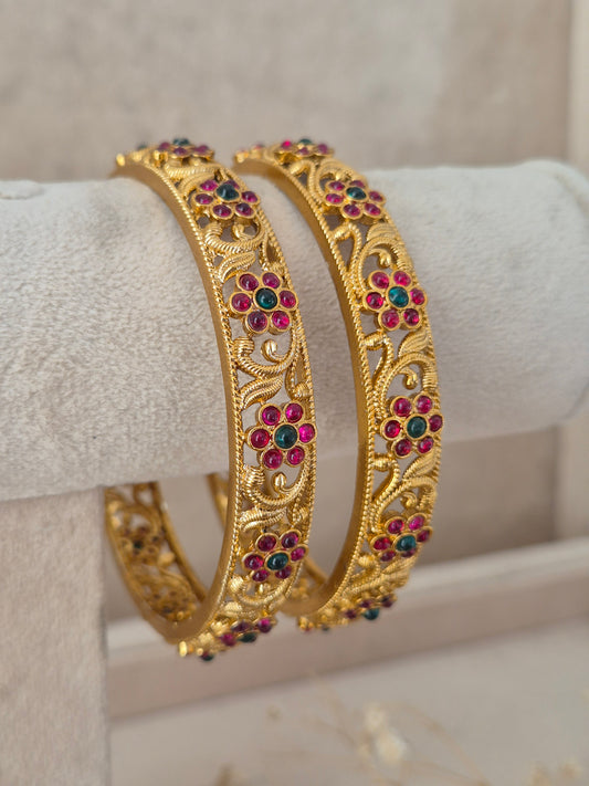 traditional gold-plated ethnic bangles with floral ruby red and emerald green stone detailing by Naitri.in