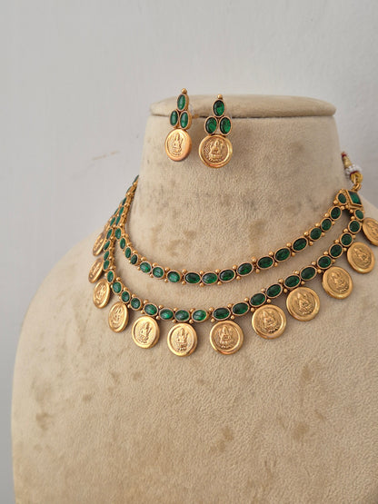 Indian-style golden coin necklace set with two rows of emerald green stones and matching drop earrings by naitri.in