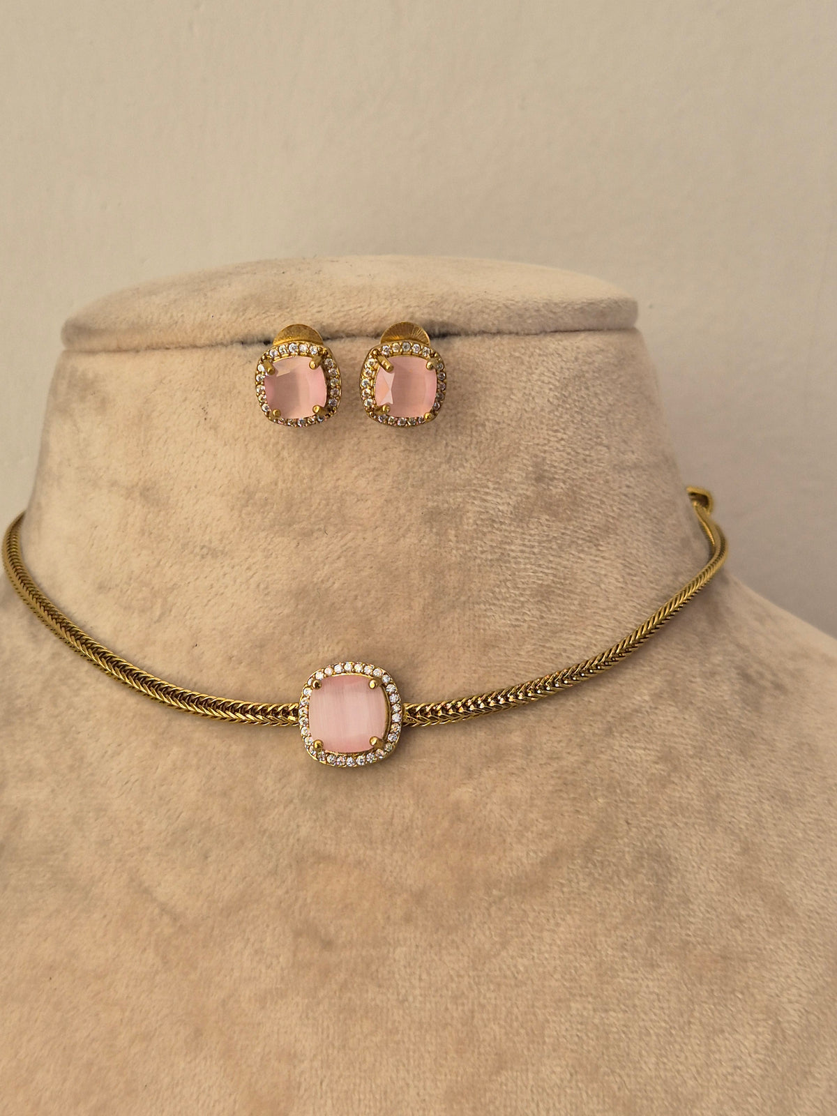 Delicate gold choker necklace with a blush pink stone pendant and matching stud earrings by naitri.in