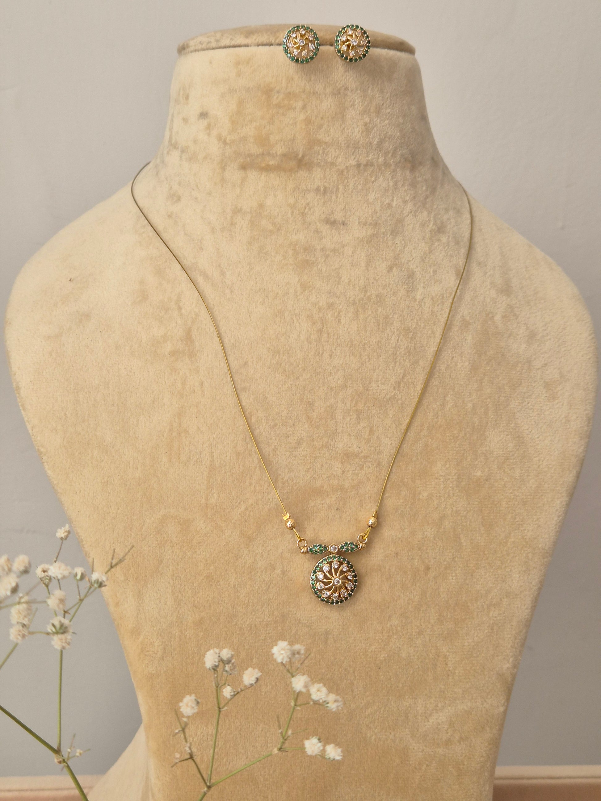 Gold-toned imitation jewelry set with invisible chain, pendant, and stud earrings by naitri.in