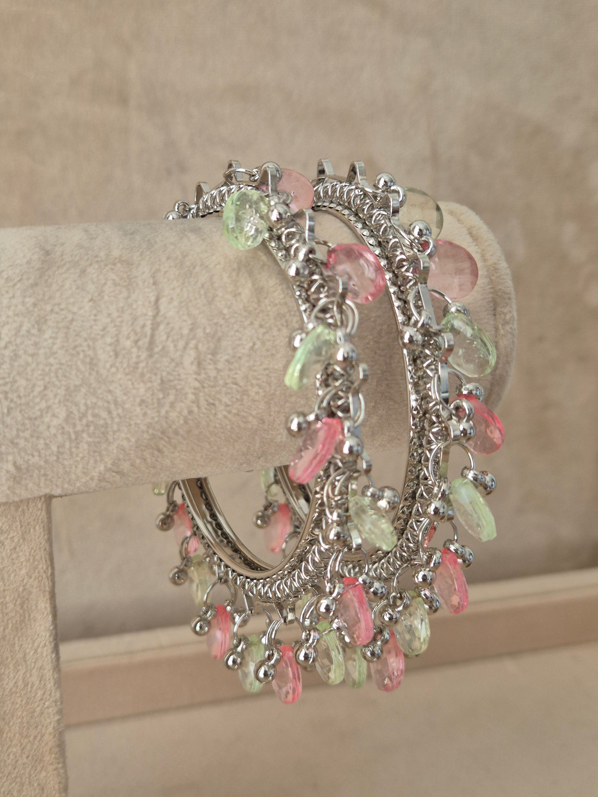 Close-up of Naitri Eartha premium oxidized silver bracelets showcasing traditional Indian tribal craftsmanship with dangling multi-color pastel stone charms