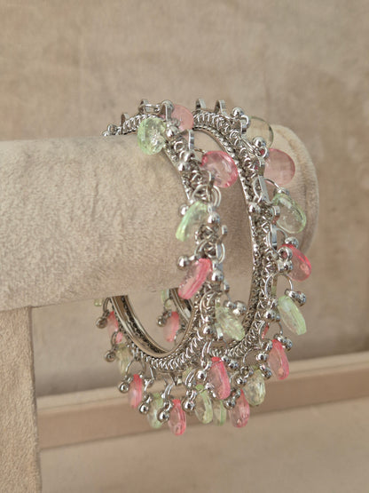 Close-up of Naitri Eartha premium oxidized silver bracelets showcasing traditional Indian tribal craftsmanship with dangling multi-color pastel stone charms