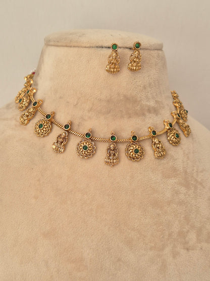 Gold-toned traditional jewelry set including a necklace with small deity-shaped charms and green stone accents, plus matching earrings by naitri.in