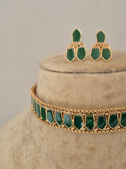 Gold-toned jewelry set featuring a choker necklace and matching drop earrings, both decorated with green teardrop-shaped stones, by naitri.in