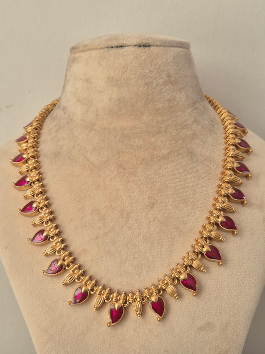 Traditional gold necklace featuring teardrop ruby red stone clusters with intricate antique embellishments, by naitri.in