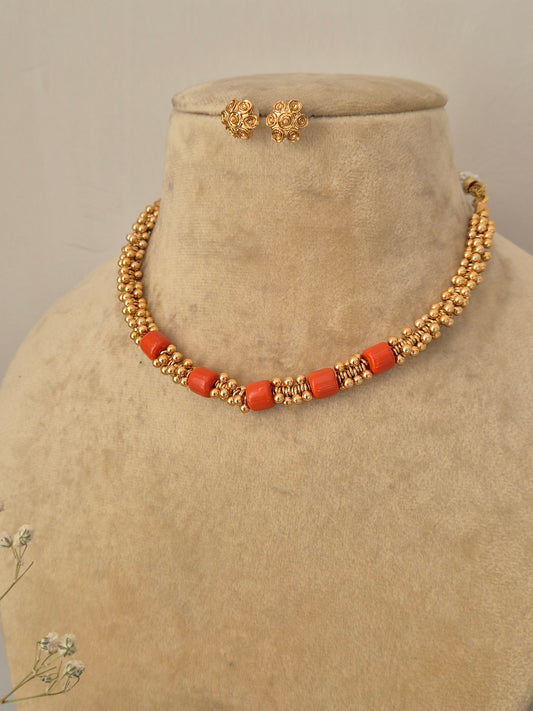 Modern Indian choker necklace set made from polished brass alloy, showcasing vibrant red stone accents paired with intricate gold bead elements from the Naitri collection by naitri.in