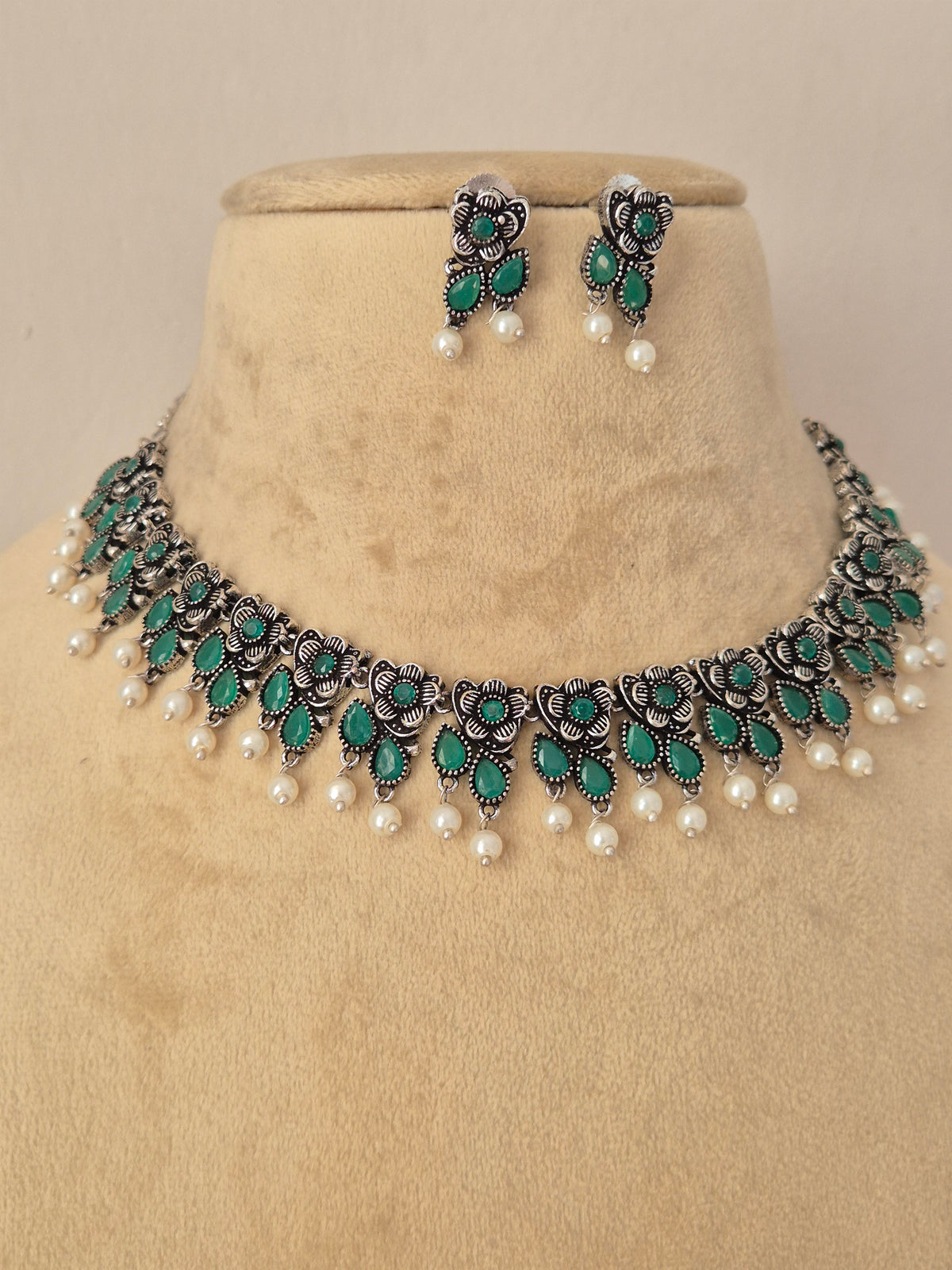 Pair of oxidized silver floral motif choker necklace with matching green stone earrings  by Naitri