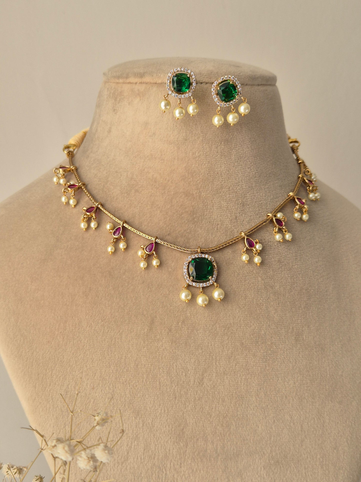 Naitri Golden Handmade imitation necklace set with green stones and polished brass finish.