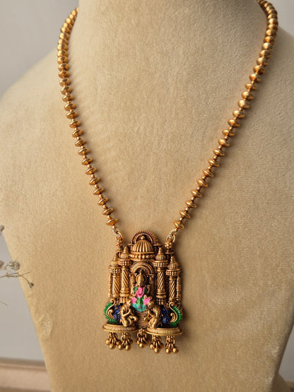 Handcrafted Devanshi temple necklace set in golden brass with intricate deity carvings and multicolored stone embellishments by naitri.in