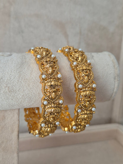 Close-up of Naitri Hitivika premium gold ethnic bangle set with traditional Indian festive craftsmanship and small pearl details. by naitri.in