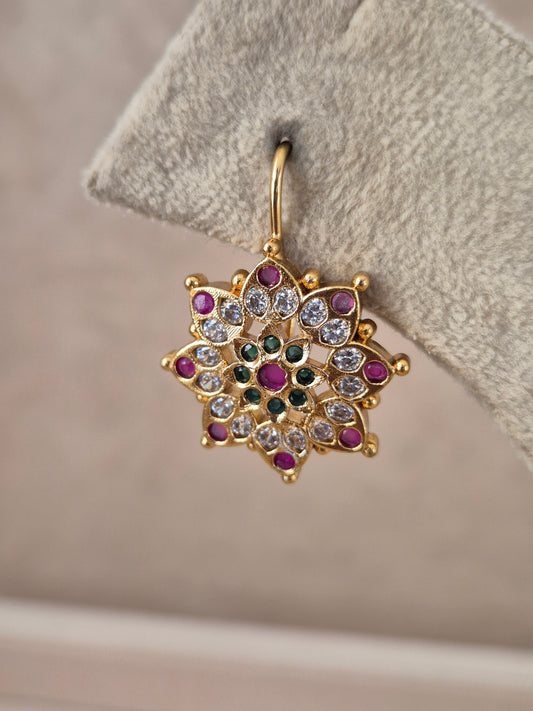 Pair of brass alloy stud earrings featuring a central cluster of vibrant red, green, and white stones arranged in a floral motif by naitri.in