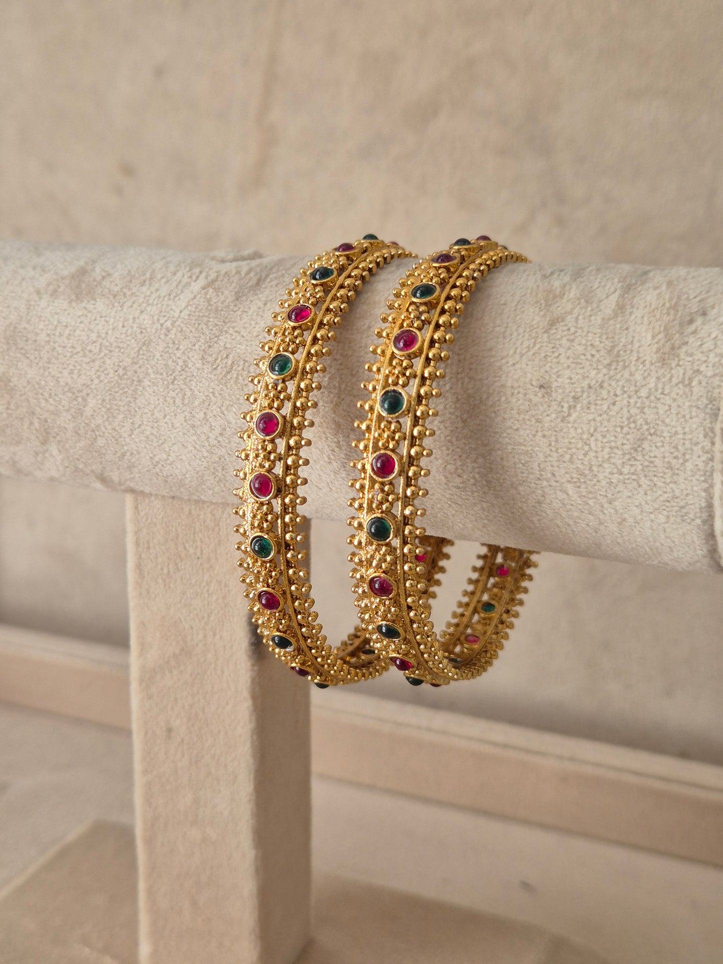 Janvika Bangles Set of 2 by Naitri featuring colorful stone embellishments and intricate gold bead edging by naitri.in