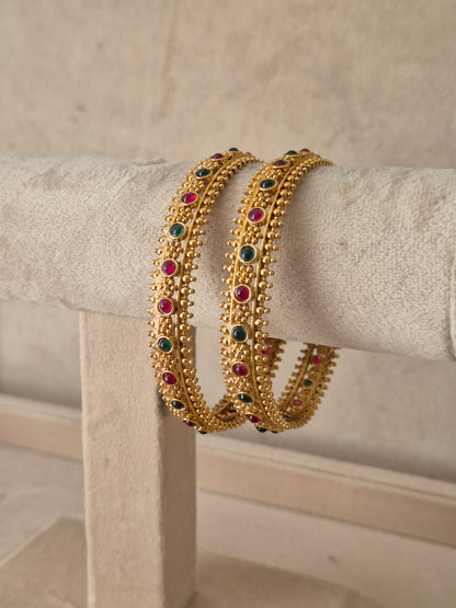 Janvika Bangles Set of 2 by Naitri featuring colorful stone embellishments and intricate gold bead edging by naitri.in