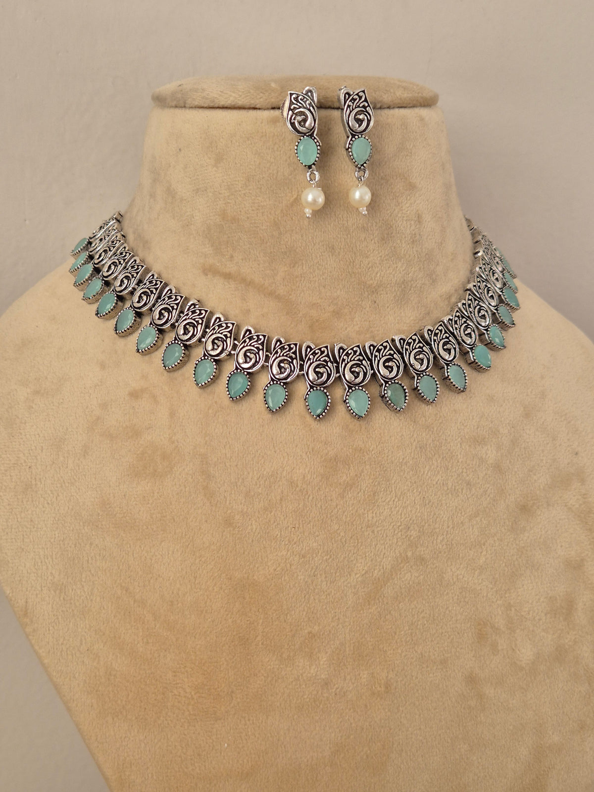 Oxidized silver-plated choker necklace and matching drop earrings inlaid with turquoise stones and small pearl drops, by naitri.in