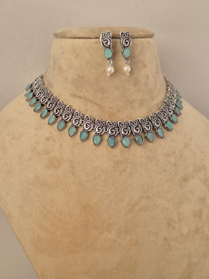Oxidized silver-plated choker necklace and matching drop earrings inlaid with turquoise stones and small pearl drops, by naitri.in