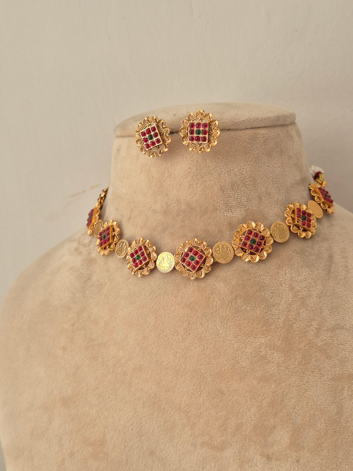 Traditional imitation choker necklace and stud earrings crafted with brass alloy and red-green stone studded round links by naitri.in