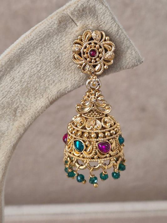 Pair of intricate brass alloy dangle earrings featuring floral-carved studs, bell-shaped jhumkas with colorful red and green stone highlights, and delicate bead drops by naitri.in