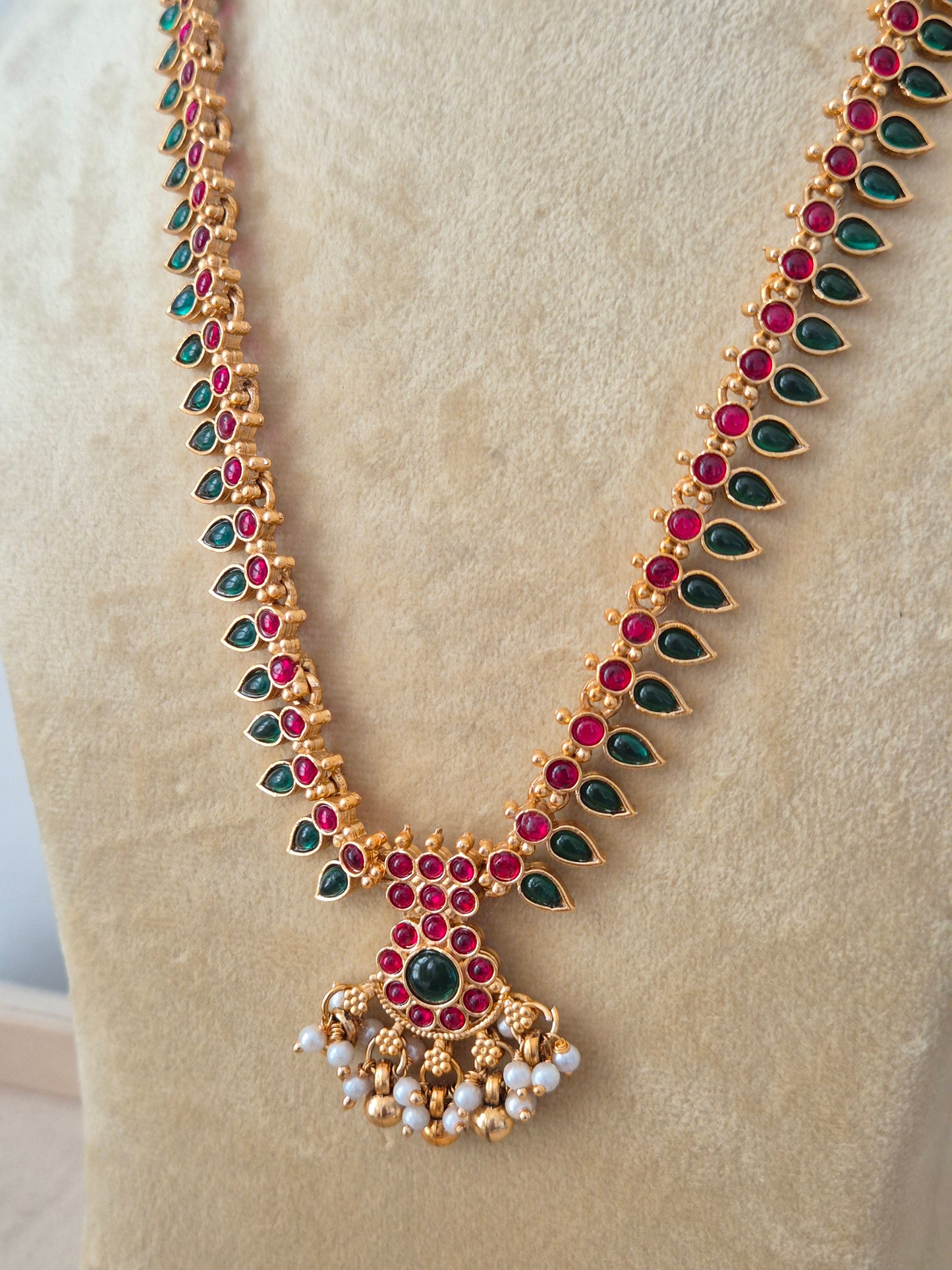 Modern Indian ethnic imitation jewelry set including a textured golden chain necklace embedded with ruby red and emerald green stones, by naitri.in