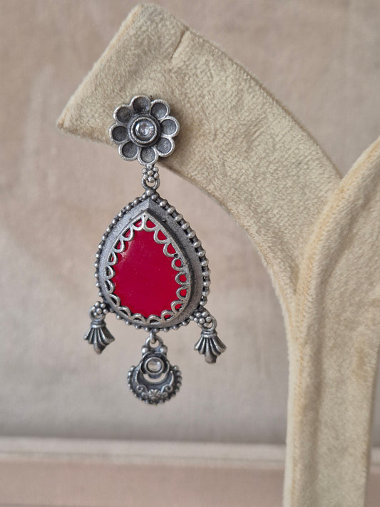 Modern Indian aesthetic silver-plated statement earrings featuring a vibrant red stone and intricate metalwork by naitri.in