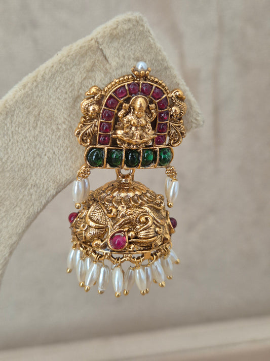 Close-up of Naitri Lochana premium gold ethnic earrings showcasing traditional Indian temple jewelry craftsmanship with vibrant gemstone embellishments and delicate pearl dangling beads by naitri.in