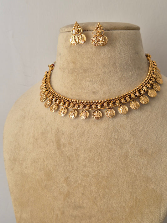 Traditional Indian coin necklace set with an antique gold finish, intricately carved deity or floral motifs, and a structured collar silhouette from the Golden Ethnic Jewellery collection by naitr.in