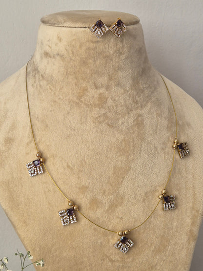 Minimalist gold-toned invisible chain necklace featuring five hanging square-shaped charms accented with purple gemstones and clear crystals, shown with matching square stud earring by naitri.in