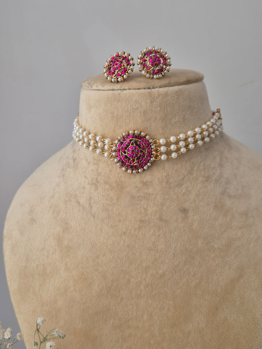 Handcrafted gold-plated brass choker necklace with white pearls and a pink floral stone centerpiece, paired with matching floral earrings By naitri.in