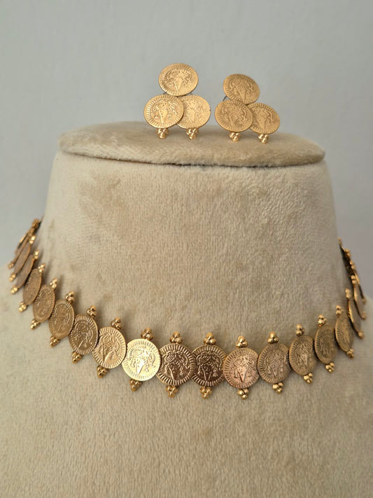 Traditional gold coin dangle earrings with intricate embossed detailing, paired with a matching choker necklace by naitri.in