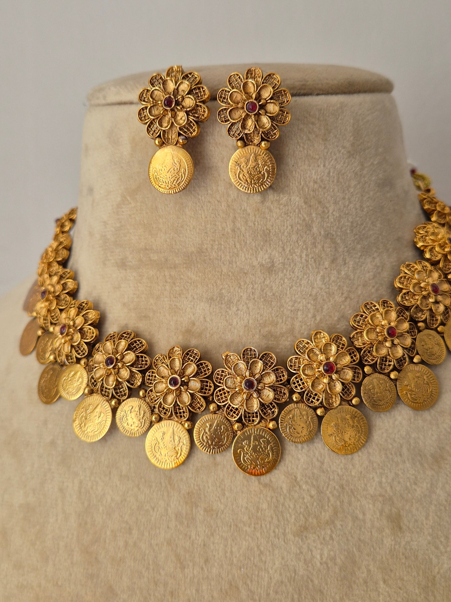 Traditional gold coin choker necklace paired with matching textured floral earrings, showcasing an antique finish from the Naitri Golden Ethnic Jewellery collection by naitri.in