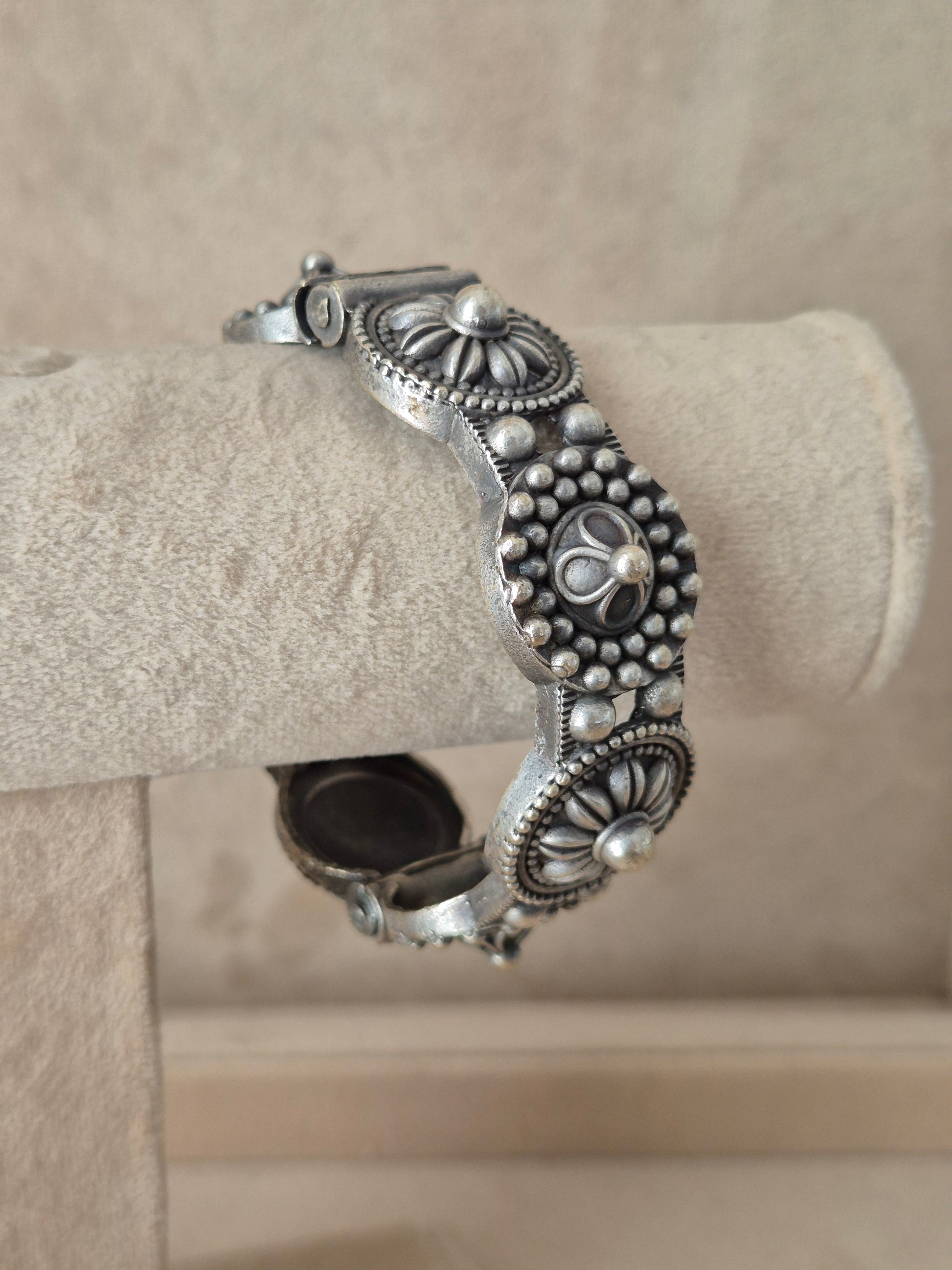 Close-up of Naitri Nafisa premium silver oxidized bangle bracelet with traditional Indian style textured leaf and flower metalwork.