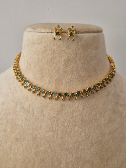 Gold-toned choker necklace and matching stud earrings with green stone embellishments by naitri.in