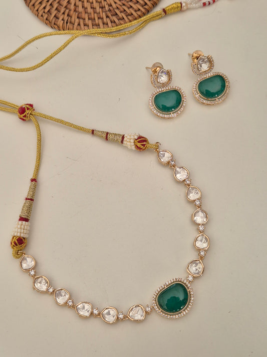 Indian bridal jewelry set featuring a green gemstone pendant necklace and matching teardrop earrings by naitri.in