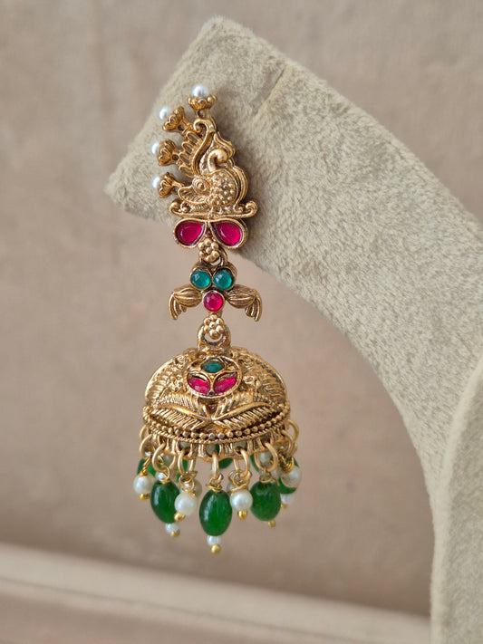 Close-up of Naitri Oindrila premium gold ethnic earrings showcasing traditional Indian temple jewelry craftsmanship with vibrant ruby red and emerald green stones and dangling bead details by naitri.in