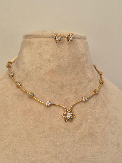 Minimalist gold and crystal floral necklace and stud earrings set by naitri.in