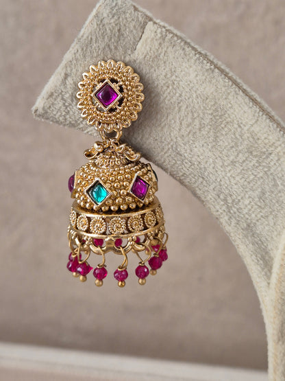 Pair of intricate brass alloy dangle earrings featuring floral studs, bell-shaped jhumkas with colorful red and green stone highlights, and delicate bead drops by naitri.in