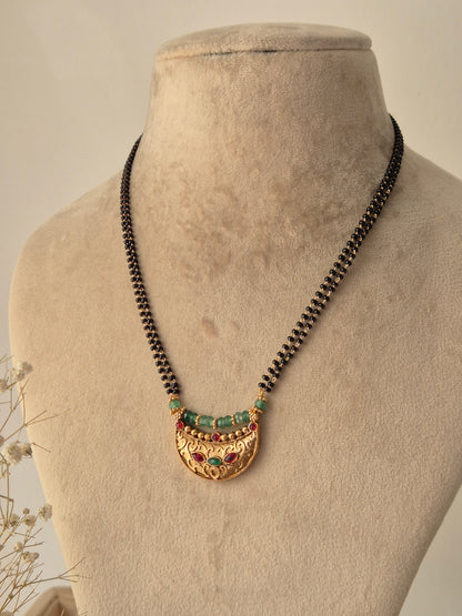 Naitri Rashi Mangalsutra with intricate gold-toned pendant and emerald-green and ruby-red stone embellishments by naitri.in