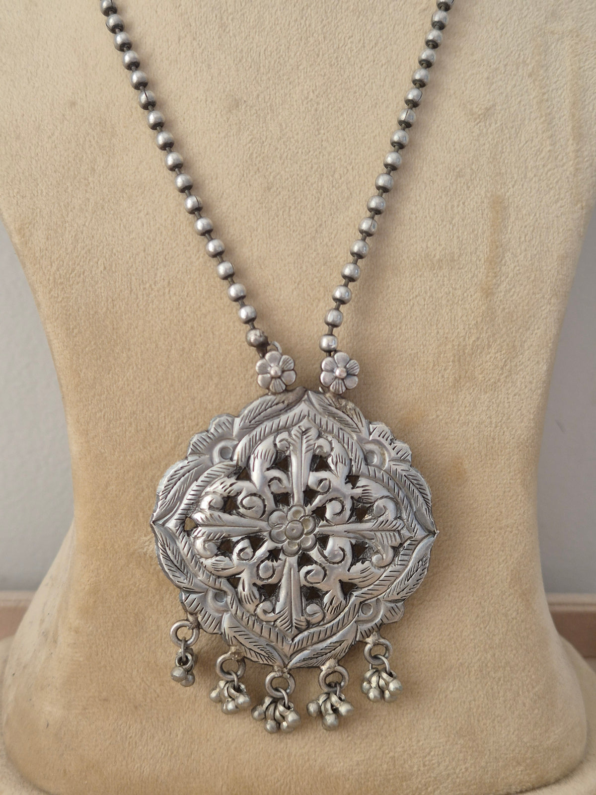 oxidized silver beaded chain necklace with a large, intricately carved geometric pendant featuring dangling bead charms with matching teardrop earrings by naitri.in
