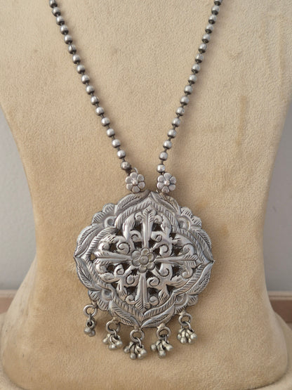 oxidized silver beaded chain necklace with a large, intricately carved geometric pendant featuring dangling bead charms with matching teardrop earrings by naitri.in